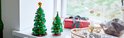 Deux sapins de Noël LEGO verts ornés sur un rebord de fenêtre.