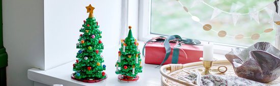 Deux sapins de Noël LEGO verts ornés sur un rebord de fenêtre.