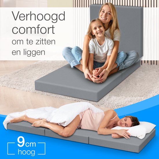 Vrouw en kind zitten op een grijze opvouwbare matras. Vrouw ligt op een matras.
