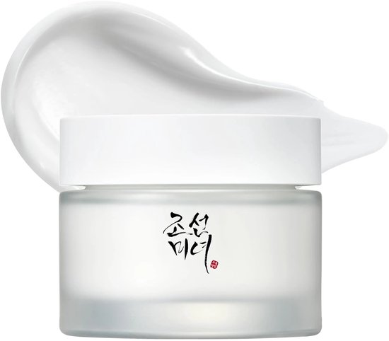 Een matglazen potje Dynasty Cream met witte dop, omringd door een veeg witte crème.