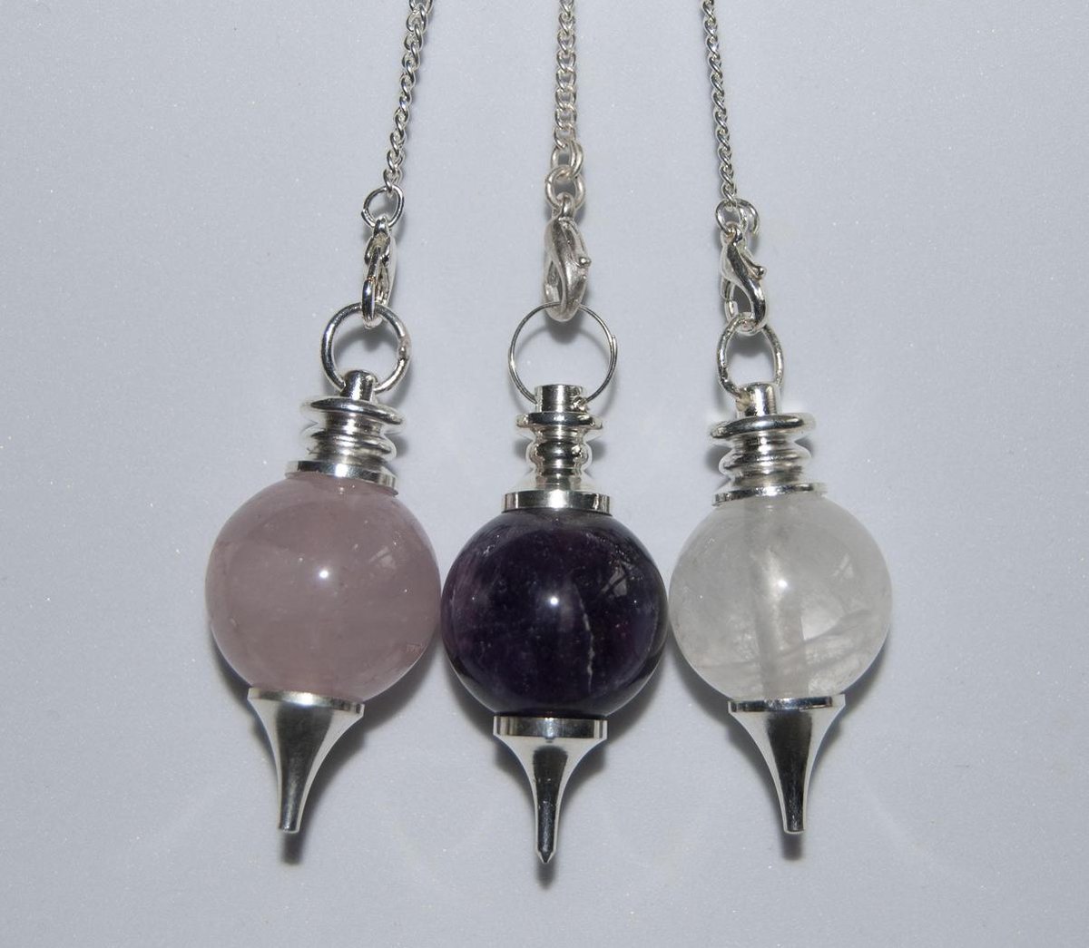 Gouden driehoek pendels. Amethist, rozenkwarts, bergkristal. Edelsteen.