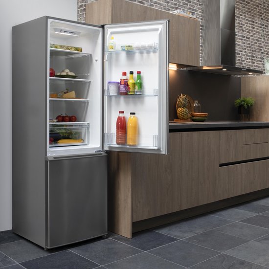 RVS koel-vriescombinatie in keukenopstelling, met open deur en gevulde schappen en lades.
