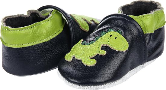 Paar donkerblauwe babyslofjes met groene dinosaurusapplicatie, groene rand en een slofje op de voorgrond.