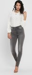 Model draagt een skinny jeans in grijs met een wit geborduurd blouse.