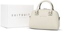 Off-white SUITSUIT Daily Bag naast de witte SUITSUIT 15th Anniversary Collection doos.