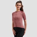 Model in roze damesfietsshirt met korte mouwen, ritssluiting en bijpassende wielrenbroek.