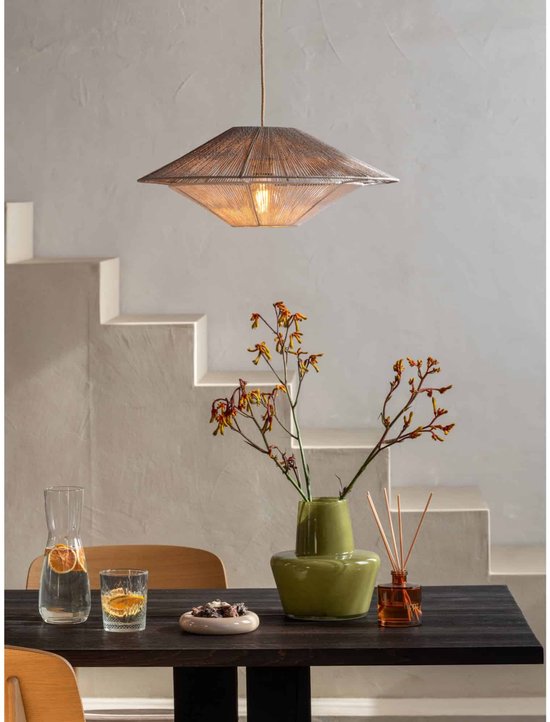 Beige touw hanglamp boven een donkerhouten eettafel met groene vaas.