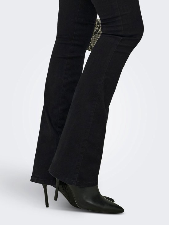 Sluiting van zwarte flared jeans gedragen met zwarte laarzen.