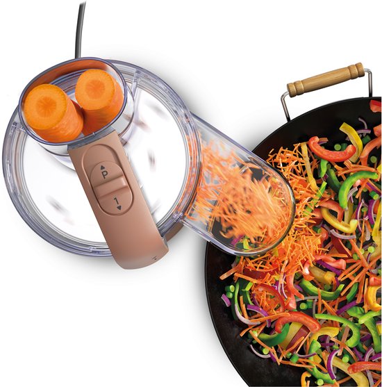 Rosekleurige Kenwood keukenmachine rasp wortel in een wok met gesneden groenten.