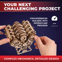 Houten V8-motor model met zichtbare mechanica, twee handen houden het vast. Tekst: YOUR NEXT CHALLENGING PROJECT.