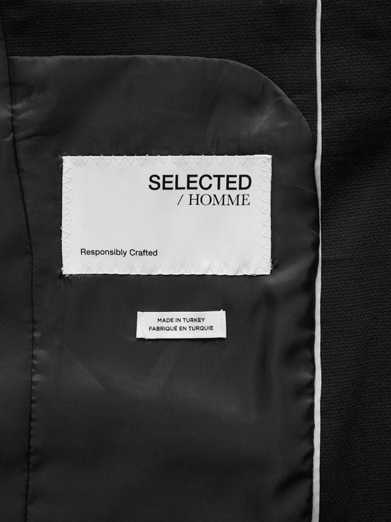 Binnenzijde van een zwarte blazer met Selected / Homme label.