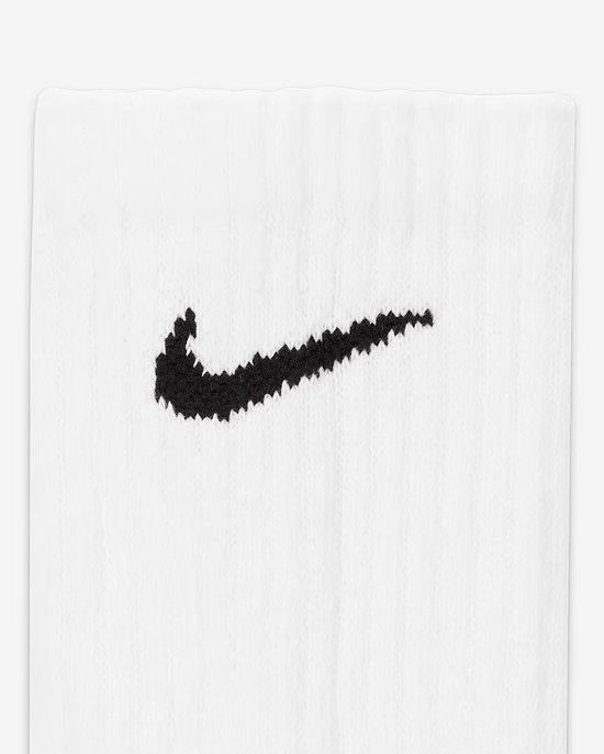 Detail van een zwart Nike logo op een witte sok.