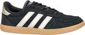Zwarte Adidas sneaker met gouden strepen en gummi zool, zijaanzicht.