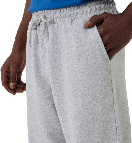 Detail van grijze joggingbroek met koord, steekzakken, huidskleurige handen.