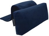 Donkerblauw nekrolkussen met label, liggend op een grijze gestoffeerde stoel.