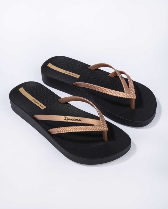 Zwarte Ipanema slippers met goudkleurige gevlochten bandjes en een platformzool.