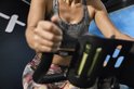 Vrouw in sportkleding draagt een zwarte Polar hartslagsensor op haar borst, fietsend op een spinningfiets.