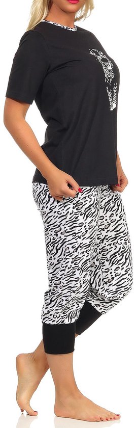 Model draagt een zwarte pyjamatop met tijgerprint, korte mouwen en een broek met tijgerprint en zwarte manchetten.