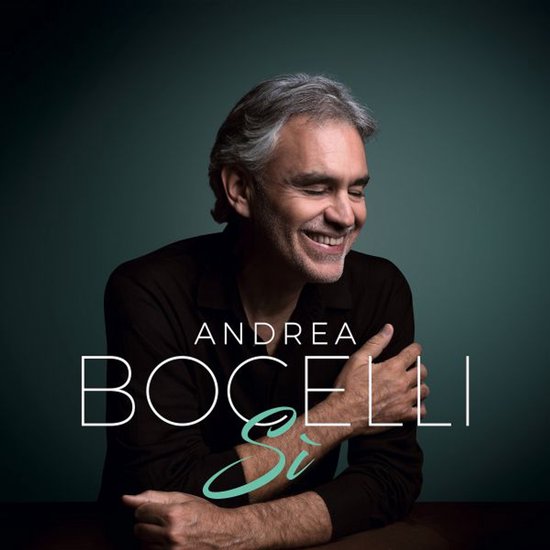 Andrea Bocelli lacht met gesloten ogen, gekleed in een bruine blouse.