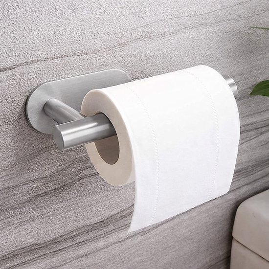 Porte-rouleau de toilette argenté en métal brossé, monté sur un mur de carrelage gris, avec un rouleau de papier toilette dessus.