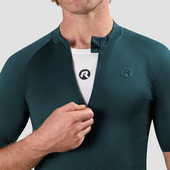 Donkergroen fietsshirt met korte mouwen, man opent de rits om een wit shirt met logo te onthullen.