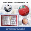 Overzicht van de inhoud van de EHBO-koffer met verband, pleisters, schaar en handschoenen.