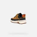 Achterkant bruine sneaker met zwarte en oranje accenten en klittenbandsluiting.
