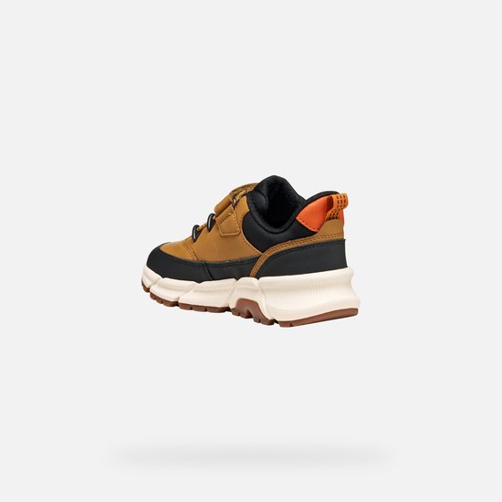 Achterkant bruine sneaker met zwarte en oranje accenten en klittenbandsluiting.