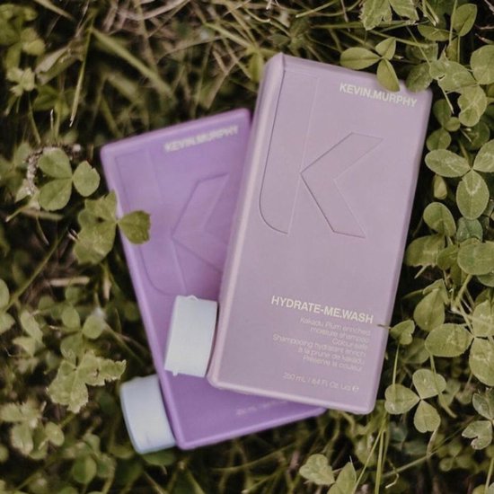 Deux bouteilles KEVIN.MURPHY violettes sur l'herbe, une avec un logo K.