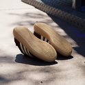 Zolen van bordeauxrode sneakers met beige zolen en Adidas logo.