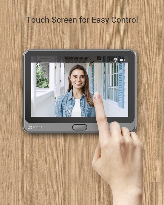 Vrouw glimlacht naar een touch screen display van de deurbelcamera.