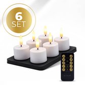 Zes witte KENN GlowPro™ oplaadbare waxinelichtjes op een zwart dienblad, met afstandsbediening.