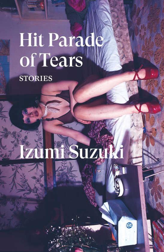 Vrouw in bruine lingerie en rode plateauhakken, liggend op een bed. Titel: Hit Parade of Tears Stories Izumi Suzuki.