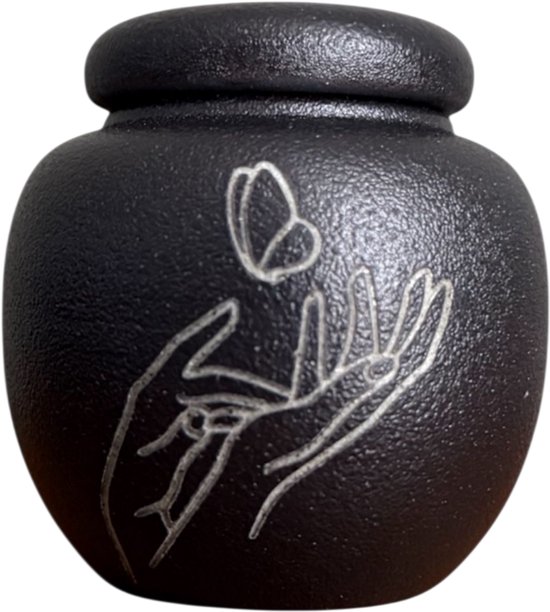 Zwarte mini-urn met lijnen van handen en een vlinder, met een ronde deksel.