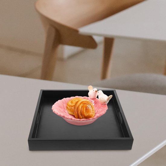 Zwart dienblad met roze schaal met gebak en twee witte vogeldecoraties.
