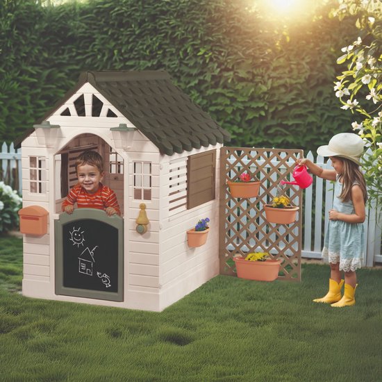 Jongen in speelhuisje, meisje met gieter bij bloembakken, Dolu Garden Playhouse in tuin.