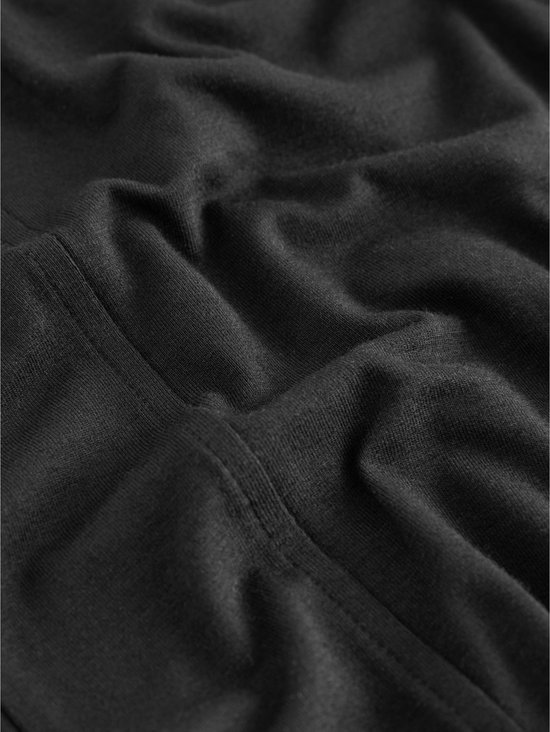 Detail van de naden van een zwarte joggingbroek.