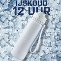 Witte drinkfles met blauwe lus, bedekt met waterdruppels, liggend op ijsblokjes. IJskoud 12 uur.