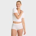 Model draagt witte crop top en witte short.