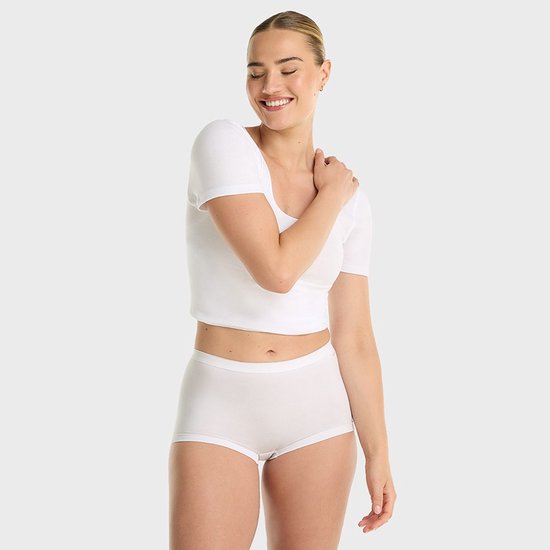 Model draagt witte crop top en witte short.