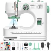 Compacte witte naaimachine met groene accenten, naald, spoelen, schaar en voetpedaal.