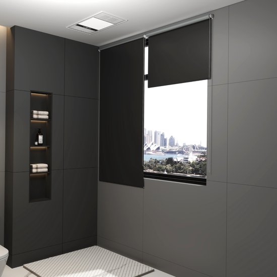 Een antracietkleurig rolgordijn gedeeltelijk gesloten voor een raam in een moderne badkamer met uitzicht op een stad.