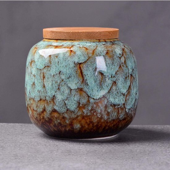 Keramische voorraadpot met bamboe deksel in turquoise en bruine tinten. Ruw, steenachtig textuur.