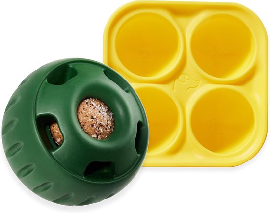 Groene Pupsicle hondenbal met lekkernijen erin, naast een geel dienblad met vier ronde holtes.