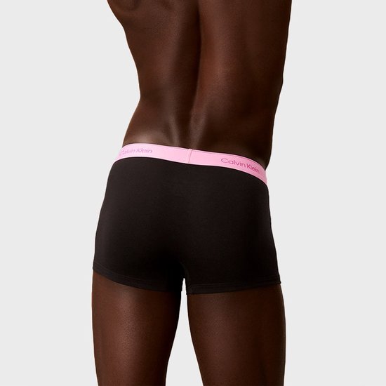 Zij-aanzicht van achterkant: Calvin Klein boxer met roze tailleband.