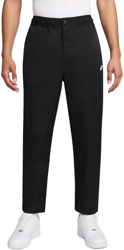 Zwarte Nike broek met kleine Nike logo, gedragen door een man.