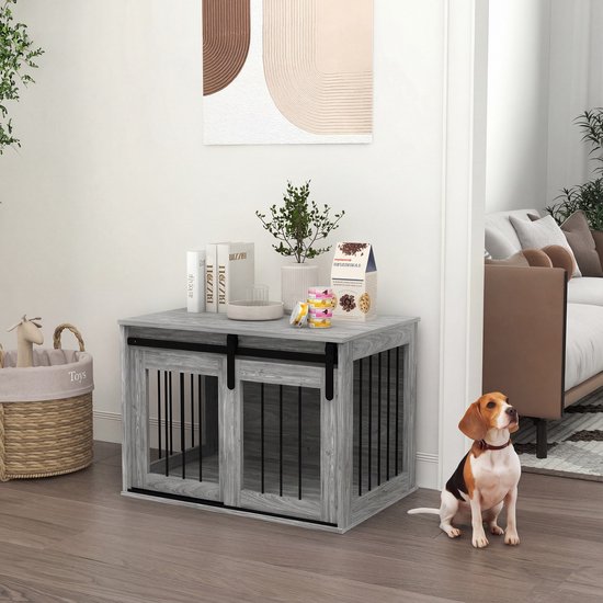 Grijze hondenbench met schuifdeuren en zwarte spijlen, naast een zittende beagle.