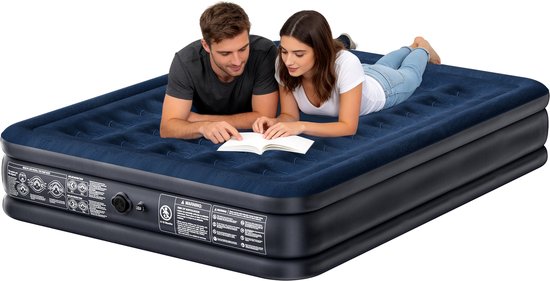 Un couple est allongé sur un matelas pneumatique bleu foncé, une femme lisant un livre.