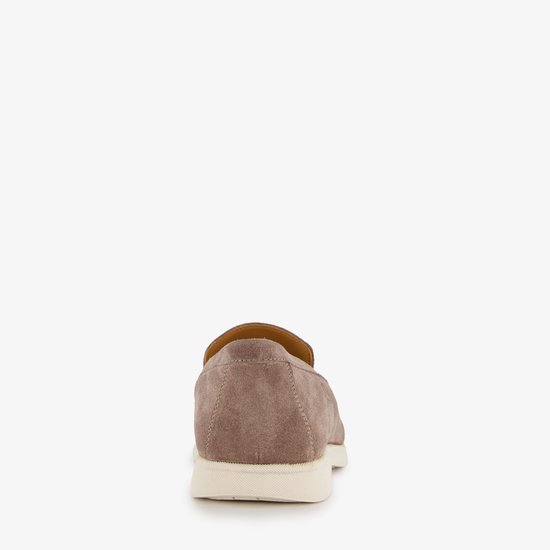 Achterkant van een bruine suède loafer met beige zool.