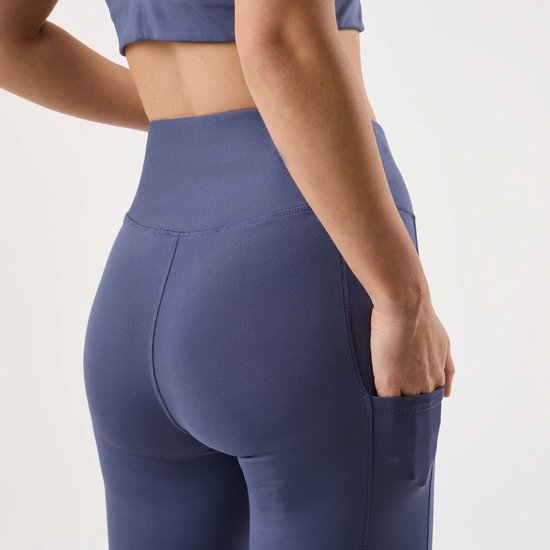 Achterkant van een paarse legging met steekzakken aan de zijkant.